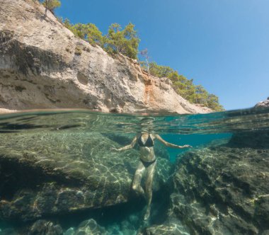 Denizde tropik tatil cennetinde bir kadın. Türk deniz kıyısında yaz tatili, Lycian Yolu 'nda plajlar, Türk Rivierası. Asyalı dişi su altı ve turkuaz okyanus çevresi.
