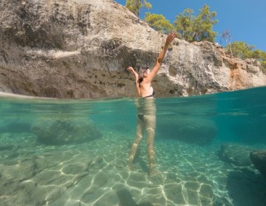 Denizde tropik tatil cennetinde bir kadın. Türk deniz kıyısında yaz tatili, Lycian Yolu 'nda plajlar, Türk Rivierası. Asyalı dişi su altı ve turkuaz okyanus çevresi.