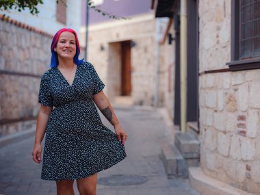 Antalya 'da yaz yürüyüşü. Renkli saçlı ve elbiseli bir kadın tarihi sokaklarını incelikle keşfediyor. Geçmiş ve şimdiki zamanı uyumlu hale getiren görsel senfoni yaratmak.