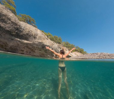 Denizde tropik tatil cennetinde bir kadın. Türk deniz kıyısında yaz tatili, Lycian Yolu 'nda plajlar, Türk Rivierası. Asyalı dişi su altı ve turkuaz okyanus çevresi.