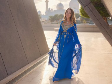 Abu Dabi 'deki Birleşik Arap Emirlikleri' ne git. Şeyh Zayed 'in yakınlarındaki mavi Arapça elbiseli kadın büyük beyaz camii. Ünlü Abu Dabi gezisi..