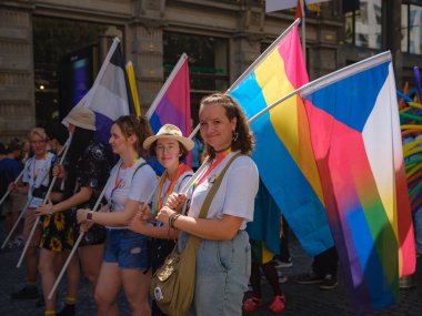 Prag, Çek Cumhuriyeti - 12 Ağustos 2023: Eski şehir merkezinde gurur ayı. Prag Onur Festivali Geçidi. Parlak bayraklı kadın