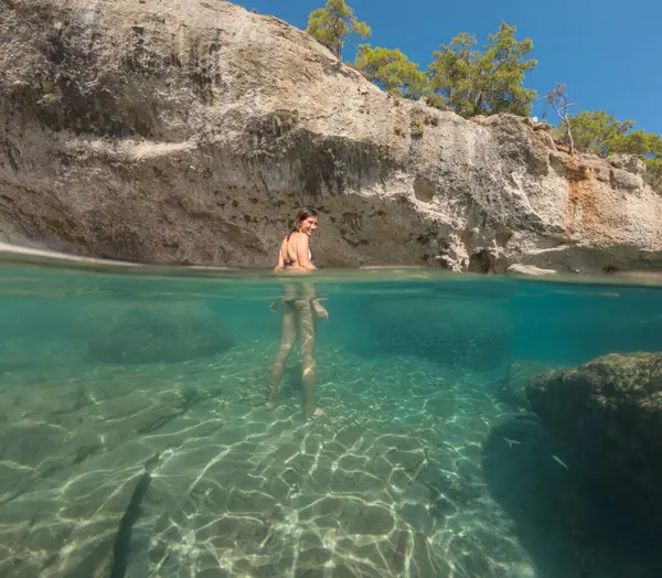 Denizde tropik tatil cennetinde bir kadın. Türk deniz kıyısında yaz tatili, Lycian Yolu 'nda plajlar, Türk Rivierası. Asyalı dişi su altı ve turkuaz okyanus çevresi.