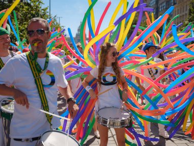 Prag, Çek Cumhuriyeti - 12 Ağustos 2023: Prag Onur Festivali Geçidi. Gey gururu sırasında renkli balonları olan kadınlar ve erkekler müzik enstrümanları çalıyor