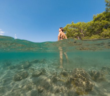 Denizde tropik tatil cennetinde bir kadın. Türk deniz kıyısında yaz tatili, Lycian Yolu 'nda plajlar, Türk Rivierası. Asyalı dişi su altı ve turkuaz okyanus çevresi.