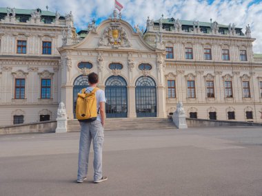 Erkek turist Avusturya 'da, başkent Viyana' da seyahat ediyor. Avrupa 'ya yaz erkek yalnız gezisi, Barok tarzı Belvedere sarayı yakınlarında parkta yürüyen mutlu genç adam..