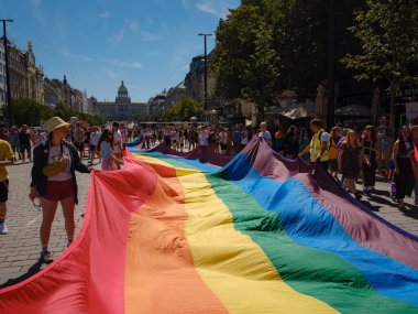 Prag, Çek Cumhuriyeti - 12 Ağustos 2023: Prag Onur Festivali Geçidi. Prag Gay Onur Yürüyüşü 'nde elinde kocaman bir gökkuşağı bayrağı olan insanlar. Wenceslas Meydanı 'nda Ulusal Müze önünde kalabalık var..