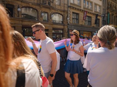 Prag, Çek Cumhuriyeti - 12 Ağustos 2023: Prag Onur Festivali Geçidi. Prag Gay Onur Yürüyüşü 'nde elinde kocaman bir gökkuşağı bayrağı olan insanlar. Wenceslas Meydanı 'nda Ulusal Müze önünde kalabalık var..