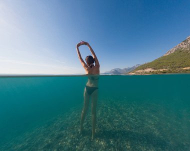 Denizde tropik tatil cennetinde bir kadın. Türk deniz kıyısında yaz tatili, Lycian Yolu 'nda plajlar, Türk Rivierası. Asyalı dişi su altı ve turkuaz okyanus çevresi.