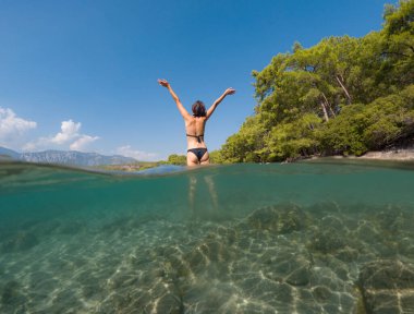 Denizde tropik tatil cennetinde bir kadın. Türk deniz kıyısında yaz tatili, Lycian Yolu 'nda plajlar, Türk Rivierası. Asyalı dişi su altı ve turkuaz okyanus çevresi.