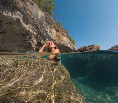 Denizde tropik tatil cennetinde bir kadın. Türk deniz kıyısında yaz tatili, Lycian Yolu 'nda plajlar, Türk Rivierası. Asyalı dişi su altı ve turkuaz okyanus çevresi.