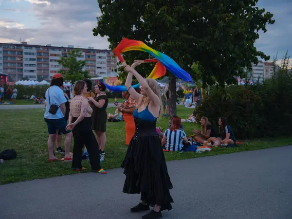 Prag, Çek Cumhuriyeti - 12 Ağustos 2023: Prag Onur Festivali Geçidi. Geçit töreninden sonra gökkuşağı kurdeleleriyle dans eden bir kadın.