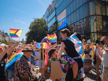 Prag, Çek Cumhuriyeti - 12 Ağustos 2023: Prag Onur Festivali Geçidi. Gökkuşağı ve diğer LGBTQ özellikleri ile parlak ve mutlu geçit ziyaretçileri, kalabalık sahnede performansı seviyor