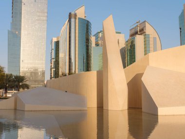 Abu Dabi 'de modern görünümlü parkı olan bir şehir silueti. Modern Qasr al Hosn Miras Müzesi ve modern gökdelenler. Abu Dabi şehrinin ünlü simgeleri,