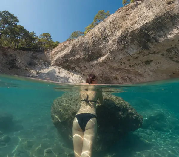 Denizde tropik tatil cennetinde bir kadın. Türk deniz kıyısında yaz tatili, Lycian Yolu 'nda plajlar, Türk Rivierası. Asyalı dişi su altı ve turkuaz okyanus çevresi.