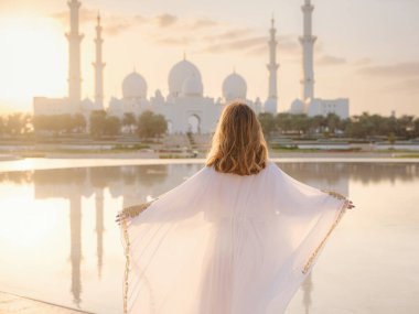 Abu Dabi 'deki Birleşik Arap Emirlikleri' ne git. Beyaz Arap elbiseli kadın Şeyh Zayed Büyük Beyaz Cami 'ye bakıyor. Ünlü Abu Dabi gezisi..