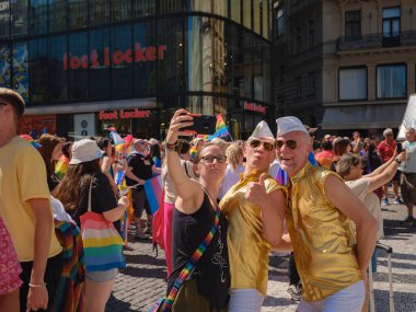 Prag, Çek Cumhuriyeti - 12 Ağustos 2023: Prag Onur Festivali Geçidi. Gökkuşağı ve diğer LGBTQ özellikleriyle parlak ve mutlu geçit ziyaretçileri, selfie çeken inanılmaz insanlar.