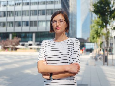 Viyana 'daki modern şehir mimarisinin arka planındaki Asyalı kadın. Düşünceli kadın hippi modern Viyana şehrinin manzarasına hayran.