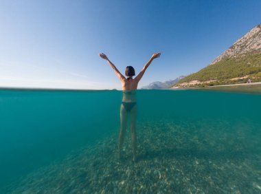 Denizde tropik tatil cennetinde bir kadın. Türk deniz kıyısında yaz tatili, Lycian Yolu 'nda plajlar, Türk Rivierası. Asyalı dişi su altı ve turkuaz okyanus çevresi.