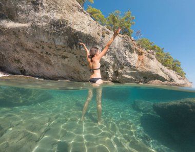 Denizde tropik tatil cennetinde bir kadın. Türk deniz kıyısında yaz tatili, Lycian Yolu 'nda plajlar, Türk Rivierası. Asyalı dişi su altı ve turkuaz okyanus çevresi.