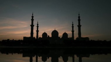 Abu Dabi 'deki Şeyh Zayed Camii' nin günbatımının çarpıcı manzarası. Büyük mimari, dingin atmosfer onu BAE 'deki İslam kültürünün ve ruhaniliğin dikkate değer bir sembolü yapıyor. Wahat Al Karama 'dan görüntü