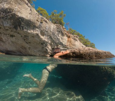 Denizde tropik tatil cennetinde bir kadın. Türk deniz kıyısında yaz tatili, Lycian Yolu 'nda plajlar, Türk Rivierası. Asyalı dişi su altı ve turkuaz okyanus çevresi.