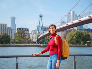 Turist kadın modern Frankfurt 'u keşfediyor, çağdaş mimari, gökdelenler ve kentsel alanlarla hareketli caddelerde yürüyor, modern yan tarafların canlı atmosferinin tadını çıkarıyor..