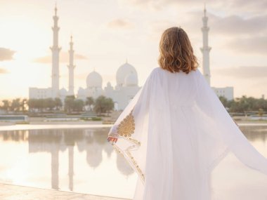 Abu Dabi 'deki Birleşik Arap Emirlikleri' ne git. Beyaz Arap elbiseli kadın Şeyh Zayed Büyük Beyaz Cami 'ye bakıyor. Ünlü Abu Dabi gezisi..