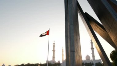 Gün batımında Wahat Al Karama Parkı 'ndan huzurlu bir manzara. Altın ışık, huzurlu manzaranın üzerine sıcak bir ışık saçıyor. İkonik Şeyh Zayed Camii arka planda güzel duruyor ve nefes kesici bir manzara yaratıyor..