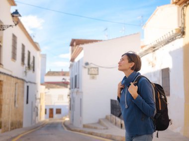 İspanya 'nın Alicante eyaletinin büyüleyici dar sokaklarında gezinen, tarihi Akdeniz mimarisi ile çevrili, barışçıl atmosfer ve kültürel ortamın tadını çıkaran genç bir kadın..