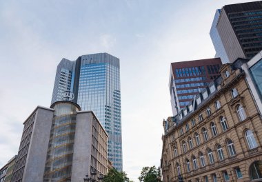 Frankfurt, Almanya - 19 Mayıs 2023: Frankfurt 'ta bulutlu bir günde iş bölgesinde modern gökdelenlerin alt görünümü