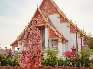 Ayutthaya, Tayland 'a git. Genç bayan turist, canlı mimari ve kültürel sembollerle çevrili modern Budist tapınaklarını keşfediyor, maneviyat ve Tayland mirasının özünü yakalıyor..