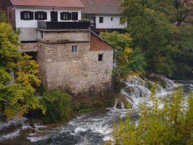 Hırvatistan 'ın Rastoke kentinin büyüleyici ayrıntıları, geleneksel ahşap evler, taş fabrikaları ve canlı yeşil manzaralar sergileniyor. Tarihi mimari ve akarsular tuhaf, kırsal bir ortam yaratıyor..