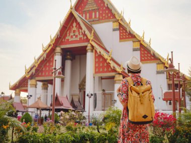 Ayutthaya, Tayland 'a git. Genç bayan turist, canlı mimari ve kültürel sembollerle çevrili modern Budist tapınaklarını keşfediyor, maneviyat ve Tayland mirasının özünü yakalıyor..