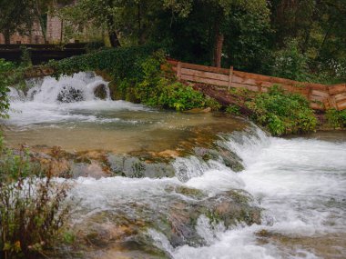 Charming details of Rastoke , Croatia, showcasing traditional wooden houses, stone mills, and vibrant green landscapes. The historic architecture and flowing streams create quaint, rustic ambiance. clipart