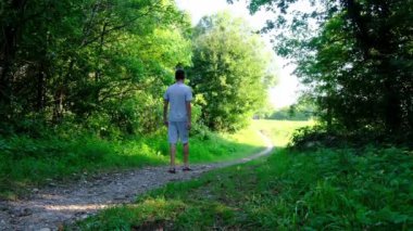 Tarlalar ve ormanlarla çevrili kırsal toprak yolda yürüyen bir adam kırsal hayatın huzurlu ve kırsal atmosferini yakalıyor. Yalnızlığı ve doğayı vurgulayan basit, sessiz bir sahne..