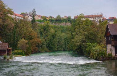 Travel to Slunj in Croatia. Breathtaking view on forest near Korana river, beautiful countryside landscape, early autumn, with hints of green transitioning to yellow. seasonal change clipart