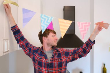 Genç adam doğum gününü evinde kutluyor. Etrafı rahat ve şenlikli bir ortam ile çevrili. Özel gününün tadını çıkarıyor, anılar yaratıyor, tatile hazırlanıyor, odayı dekore ediyor.