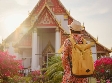 Ayutthaya, Tayland 'a git. Genç bayan turist, canlı mimari ve kültürel sembollerle çevrili modern Budist tapınaklarını keşfediyor, maneviyat ve Tayland mirasının özünü yakalıyor..