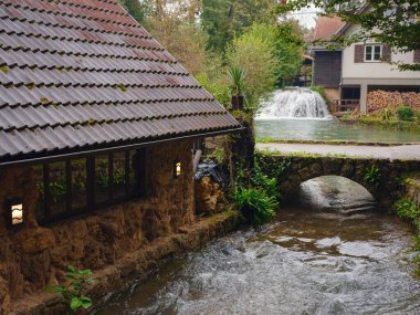 Charming details of Rastoke , Croatia, showcasing traditional wooden houses, stone mills, and vibrant green landscapes. The historic architecture and flowing streams create quaint, rustic ambiance. clipart