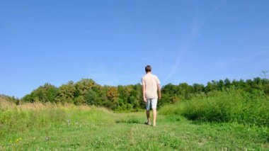 Dar bir yolda yürüyen bir adam, doğal bir manzarayla çevrili, huzurlu ve düşünceli bir atmosferi yakalıyor. Basitliğe, yalnızlığa ve doğayla bağlantıya odaklan..