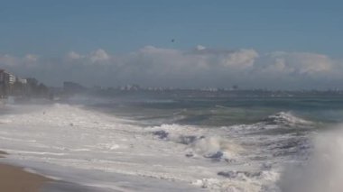 Akdeniz, Konyaalti, Antalya ve Türkiye 'de güçlü dalgalar hakim. Fırtınalı dalgalar köpüklü köpüklü deniz, mavi gökyüzü.