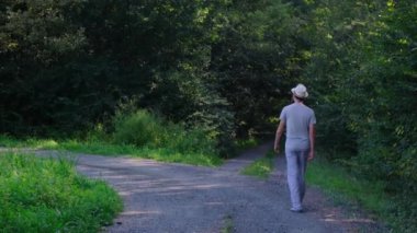 Tarlalar ve ormanlarla çevrili kırsal toprak yolda yürüyen bir adam kırsal hayatın huzurlu ve kırsal atmosferini yakalıyor. Yalnızlığı ve doğayı vurgulayan basit, sessiz bir sahne..