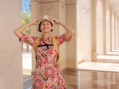 Abu Dabi 'de Qasr Al Hosn Parkı' nı keşfeden genç bir kadın. Yeşillik ve tarihi simgelerle çevrelenmiş, kentin kalbindeki sakin atmosfer ve Emirati mirasının tadını çıkarıyor..