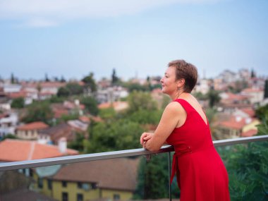 Sıcak yaz akşamları Antalya 'nın dar sokaklarında kırmızı elbiseli bir kadın yürüyor. Tarihsel atmosfer ve Akdeniz cazibesi barışçıl seyahat deneyimleri yaratır. Kalechi manzarası