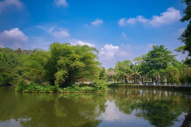 Infrastructure of the Kuala Lumpur Perdana Botanical Garden featuring walking paths, benches, decorative bridges, and well-maintained facilities integrated into the lush tropical environment. clipart