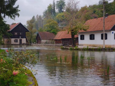 Hırvatistan 'ın Rastoke kentinin büyüleyici ayrıntıları, geleneksel ahşap evler, taş fabrikaları ve canlı yeşil manzaralar sergileniyor. Tarihi mimari ve akarsular tuhaf, kırsal bir ortam yaratıyor..