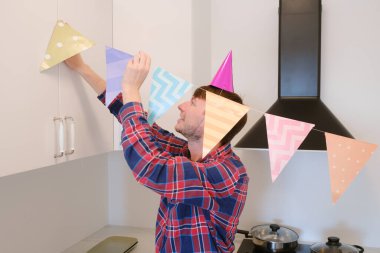 Genç adam doğum gününü evinde kutluyor. Etrafı rahat ve şenlikli bir ortam ile çevrili. Özel gününün tadını çıkarıyor, anılar yaratıyor, tatile hazırlanıyor, odayı dekore ediyor.