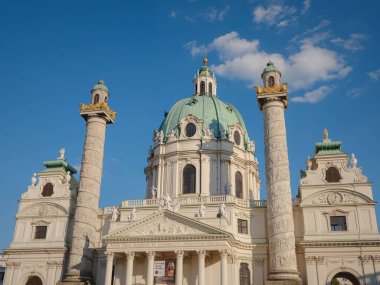Viyana, Avusturya - 31 Temmuz 2023: Karlsplatz Meydanı 'ndaki Karlskirche Kilisesi gün batımında. Bir Avrupa ülkesinin Viyana başkenti Avusturya. Yaz mimarisi ve kültüründe Viyana 'yı keşfetmek,