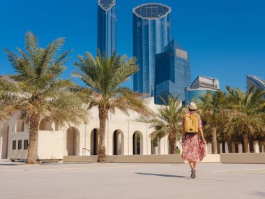 Abu Dabi 'de Qasr Al Hosn Parkı' nı keşfeden genç bir kadın. Yeşillik ve tarihi simgelerle çevrelenmiş, kentin kalbindeki sakin atmosfer ve Emirati mirasının tadını çıkarıyor..